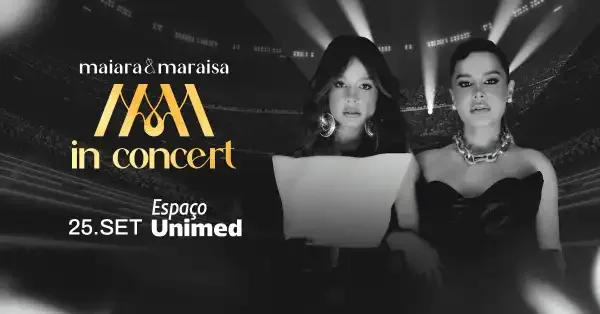 Maiara and Maraisa performing on stage during a concert in São Paulo, illuminated by bright concert lights.